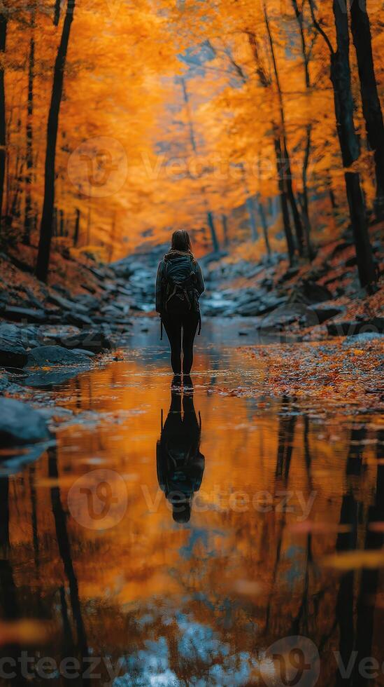 Beautiful autumn hike in a serene forest with vibrant orange foliage and calm water reflections photo