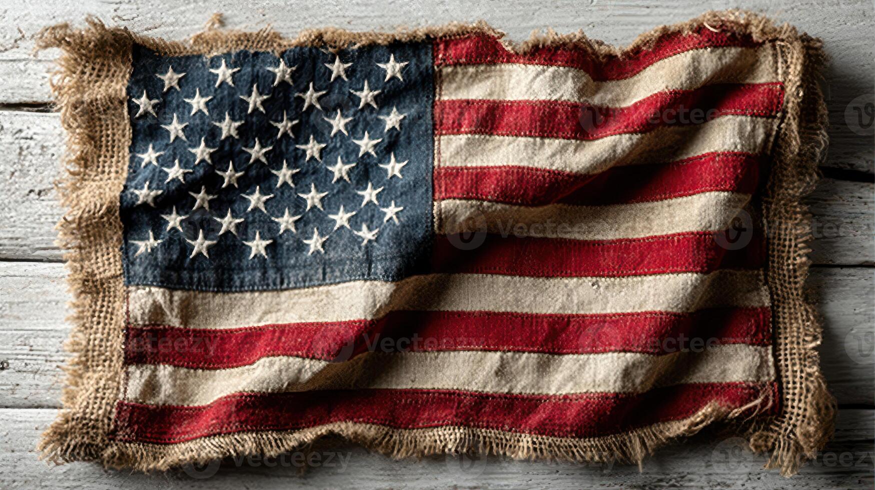 Worn American flag displayed on a rustic wooden surface highlighting the texture and colors of the national emblem photo