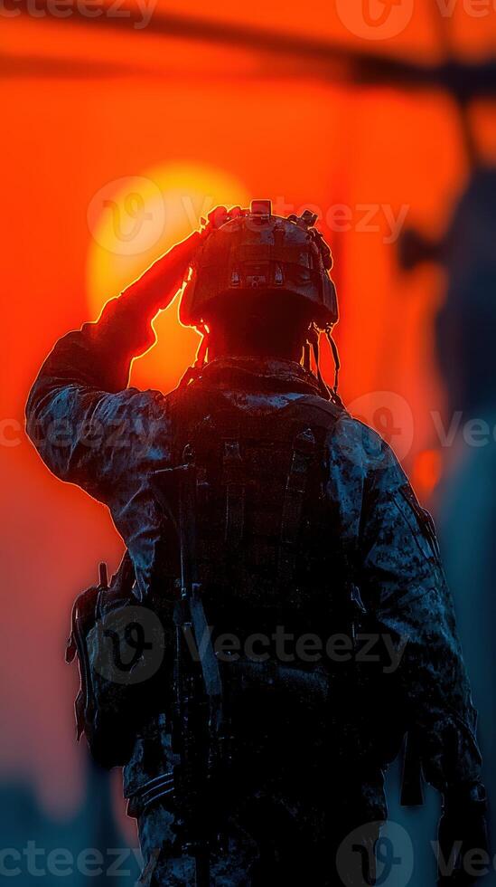 Military personnel saluting against a vibrant sunset over the horizon in a display of respect photo