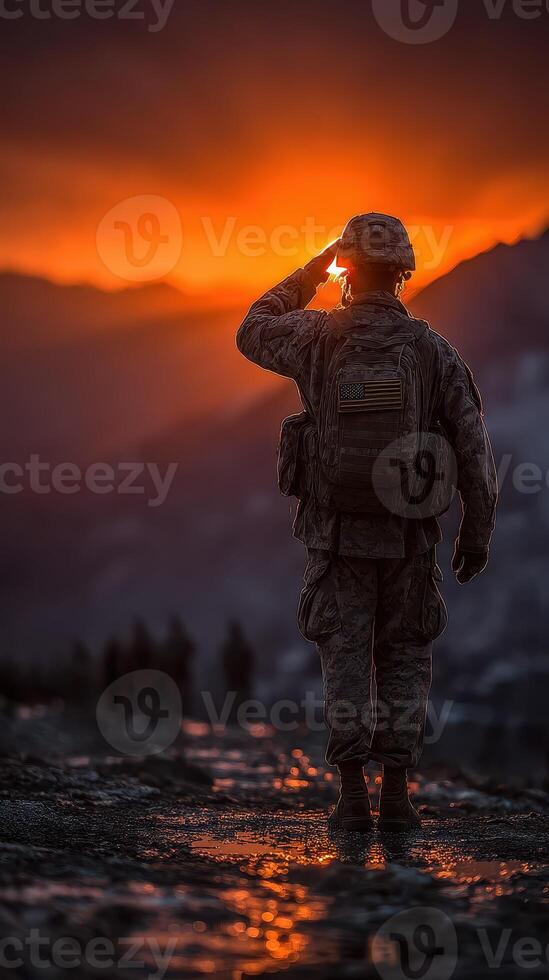 Soldier saluting at sunset in a mountainous region highlighting dedication and camaraderie among troops photo