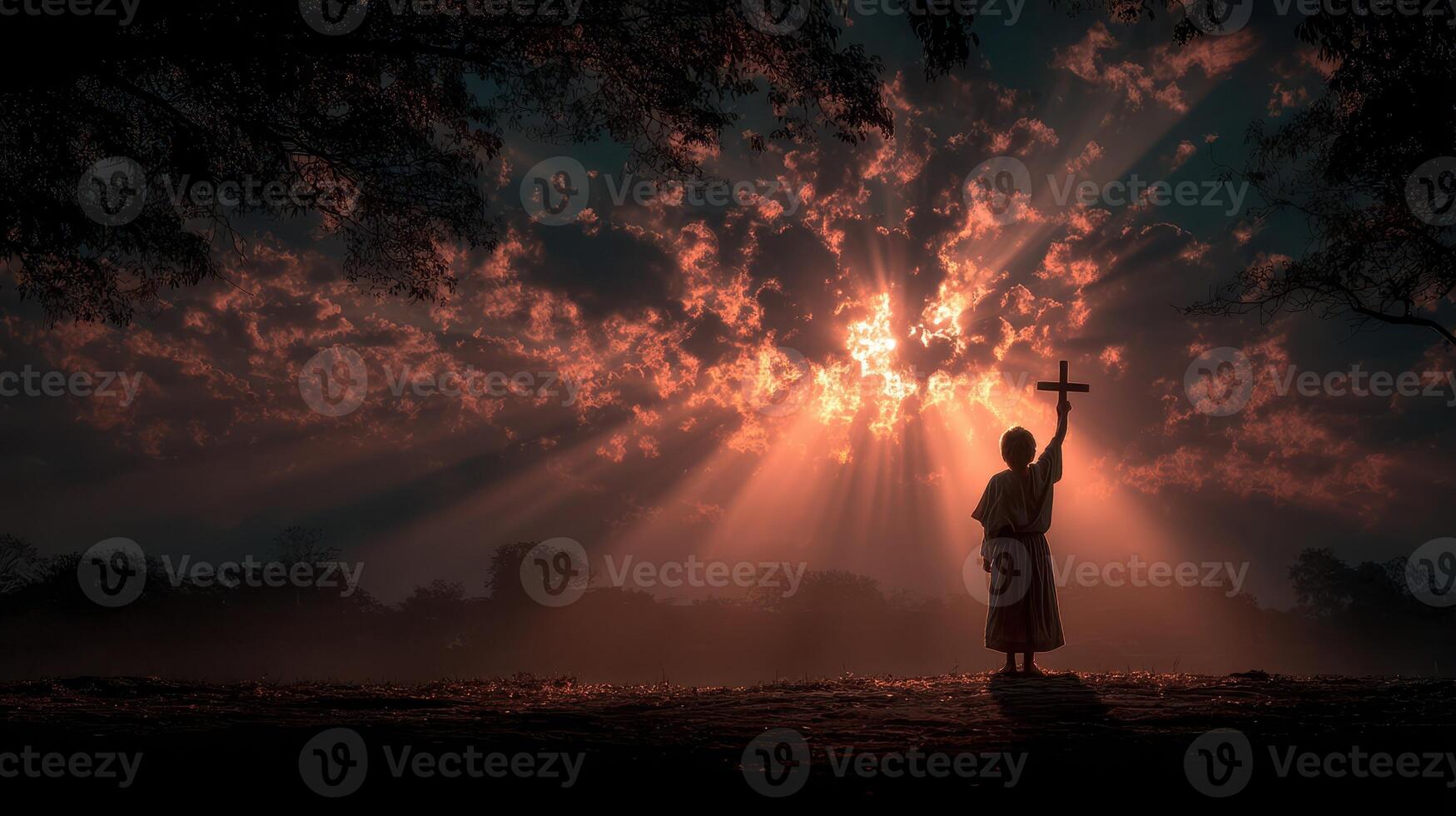 Silhouette of a person holding a cross against a dramatic sunset in a serene landscape photo