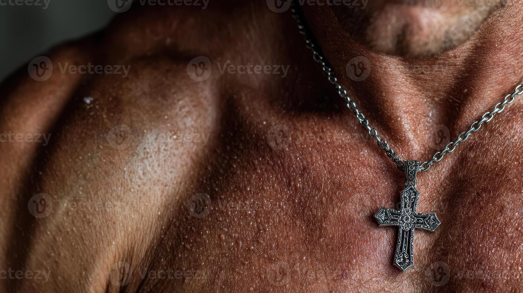 Muscular man showcasing a silver necklace with a cross in a well-lit indoor setting photo