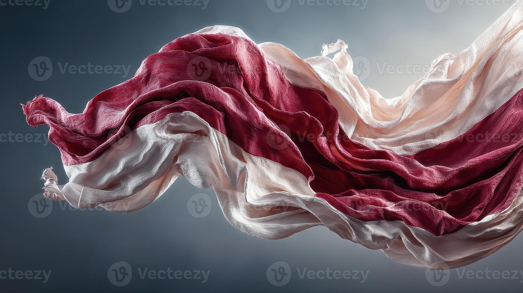 Flowing fabric with red and white colors undulates gracefully in a light backdrop photo