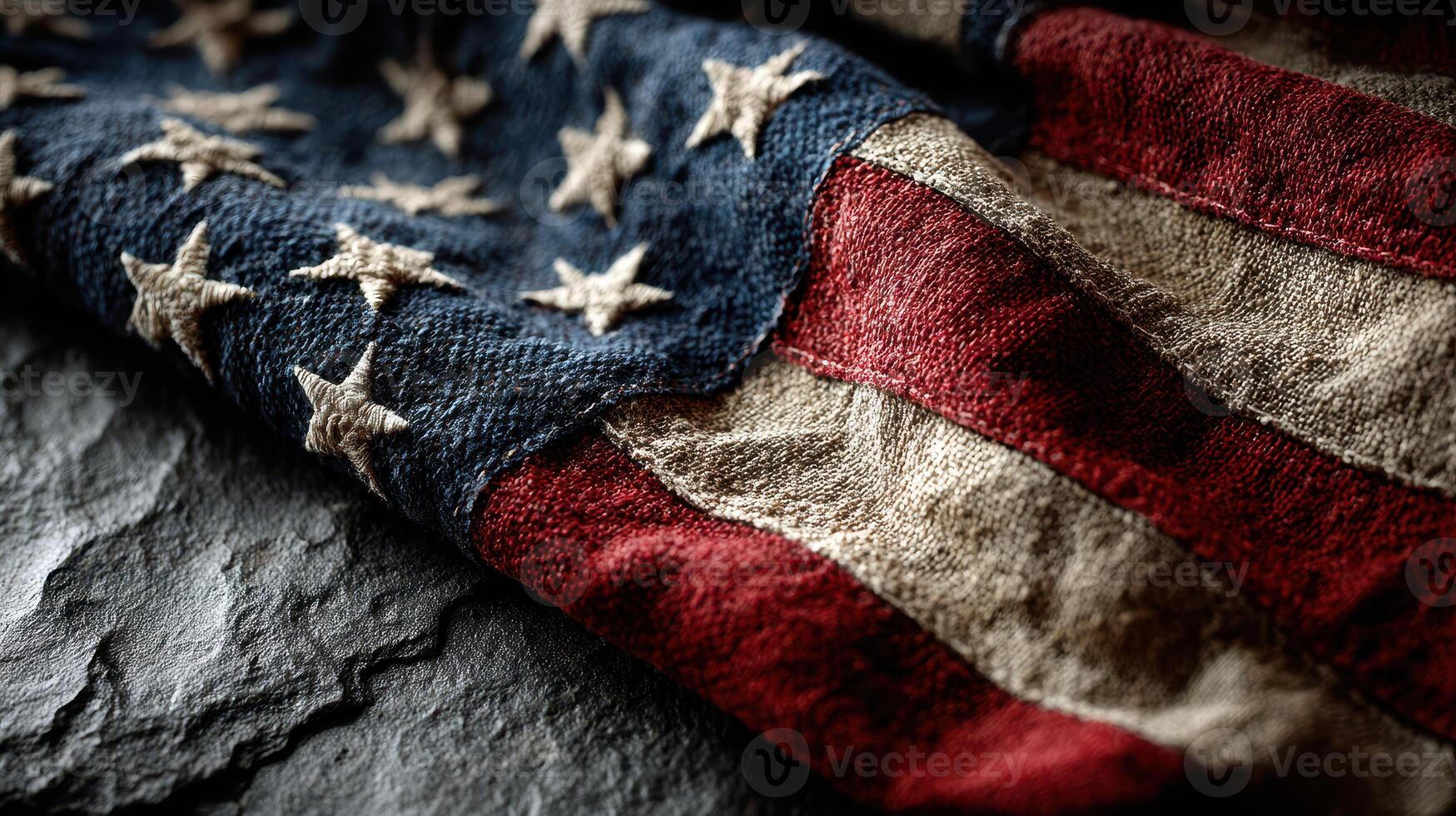 Old American flag folded on dark stone surface with visible texture and colors representing patriotism and history photo