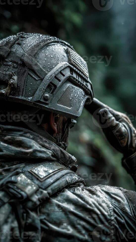 Military soldier in a wet environment adjusting helmet during a tactical mission in a forest setting at dusk photo