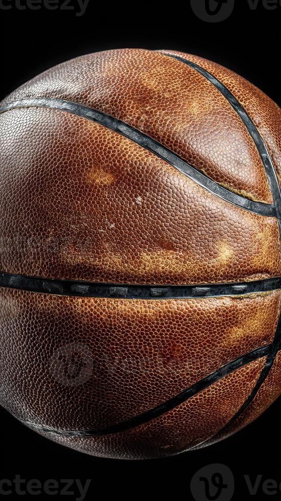 Basketball resting on a black surface highlighting its texture and details at a close range photo