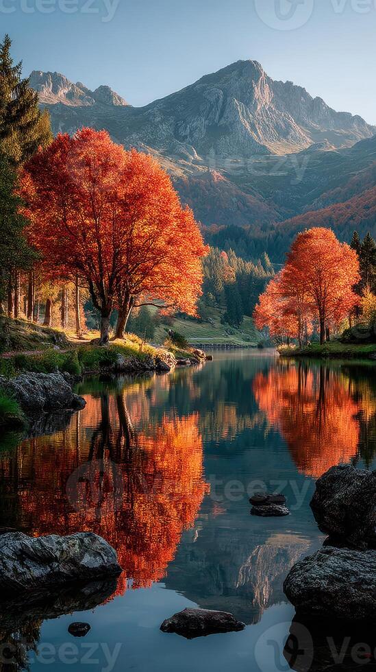 Autumn colors reflecting in a serene lake surrounded by mountains during golden hour photo