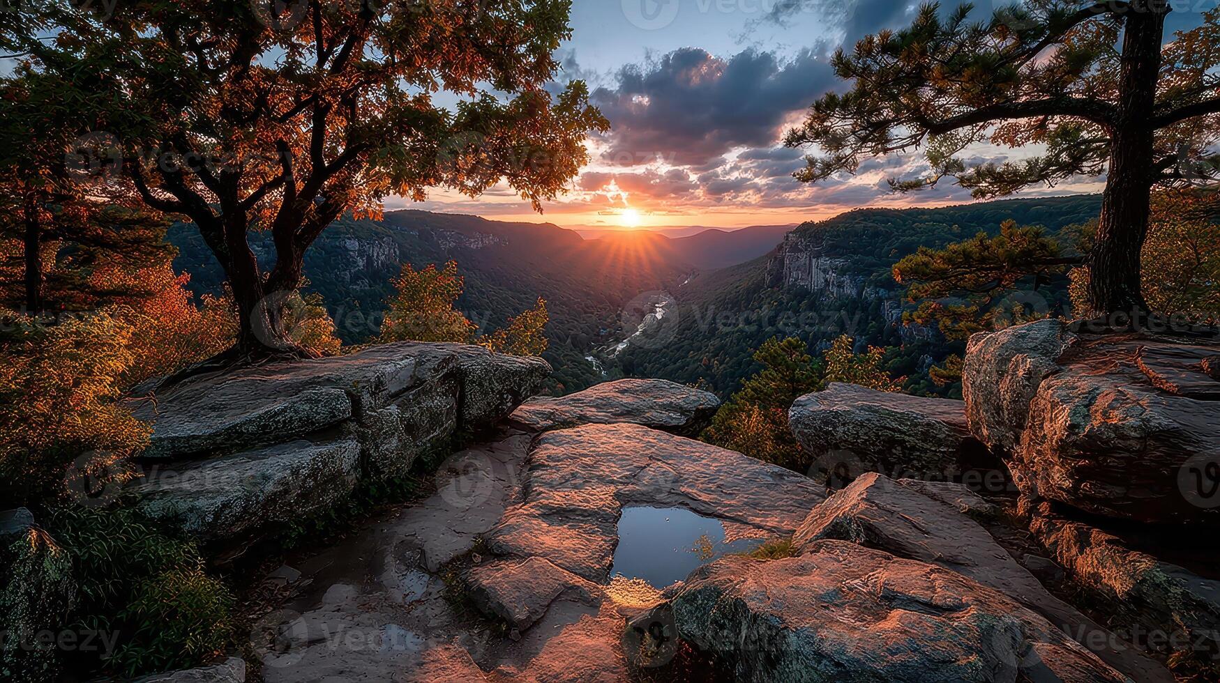 Scenic view of a sunset over a valley from a rocky overlook surrounded by trees in a natural landscape photo