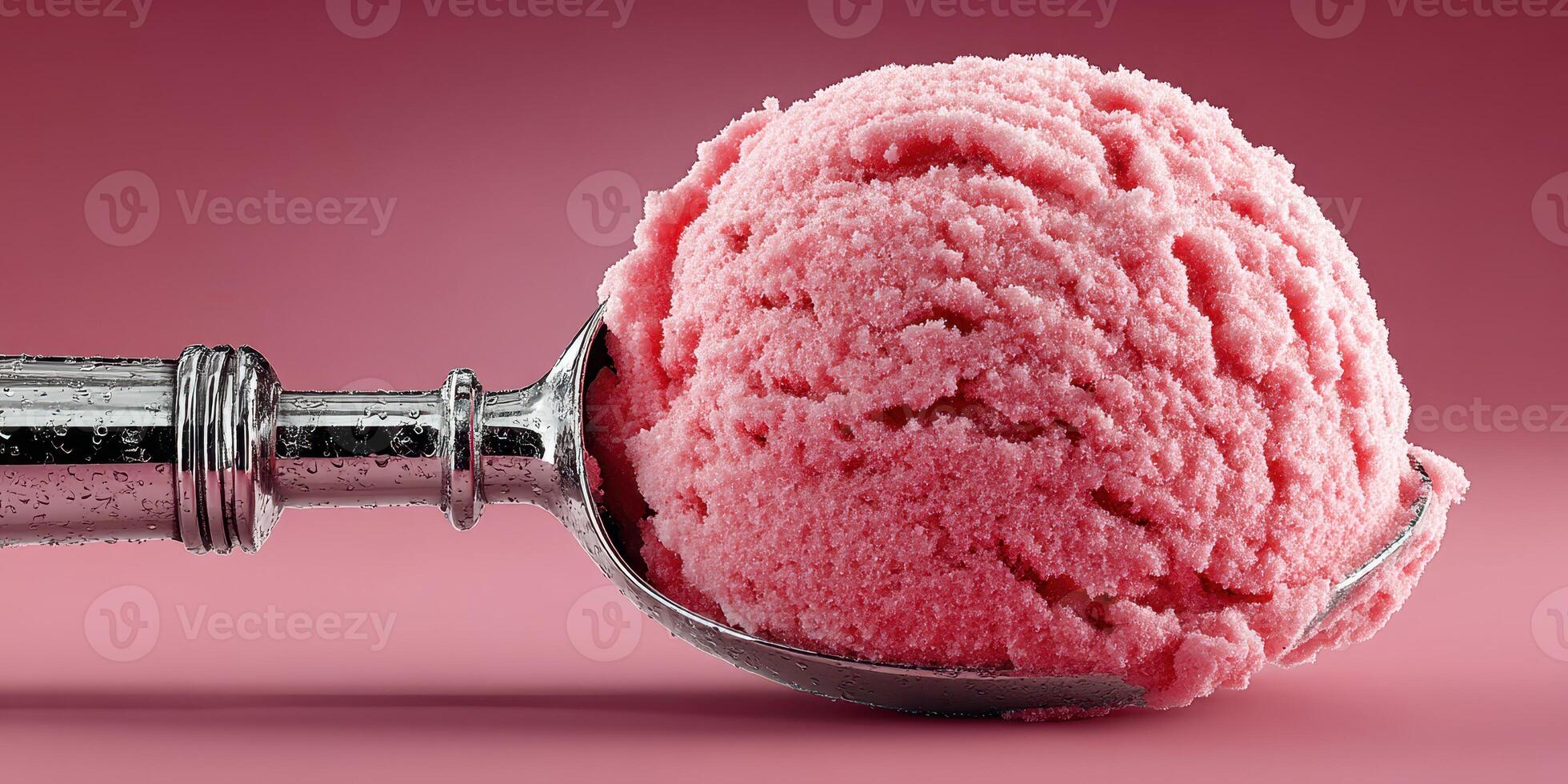 Bright pink sorbet scoop with a silver ice cream scoop on a soft pink backdrop photo