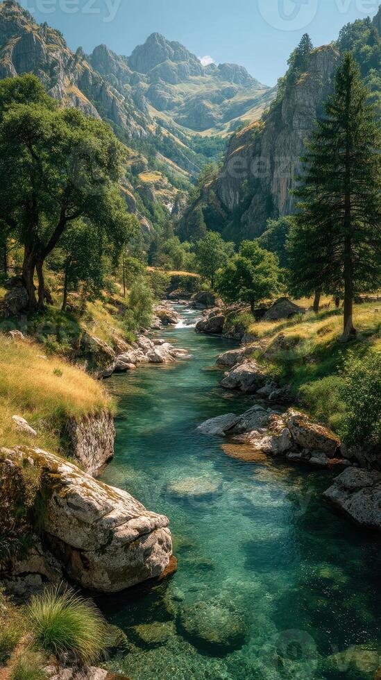 Breathtaking mountain landscape with a serene river flowing through lush greenery under a clear blue sky photo