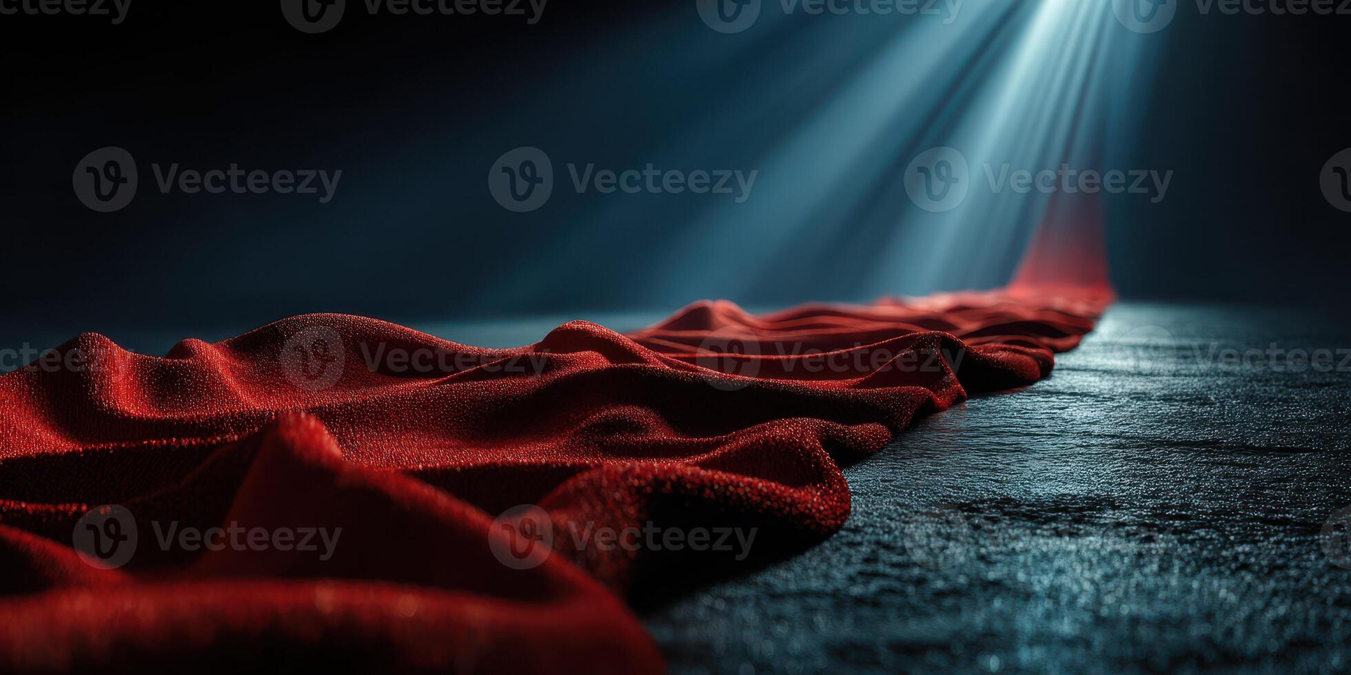Flowing red fabric on textured surface under dramatic light creates captivating atmosphere photo