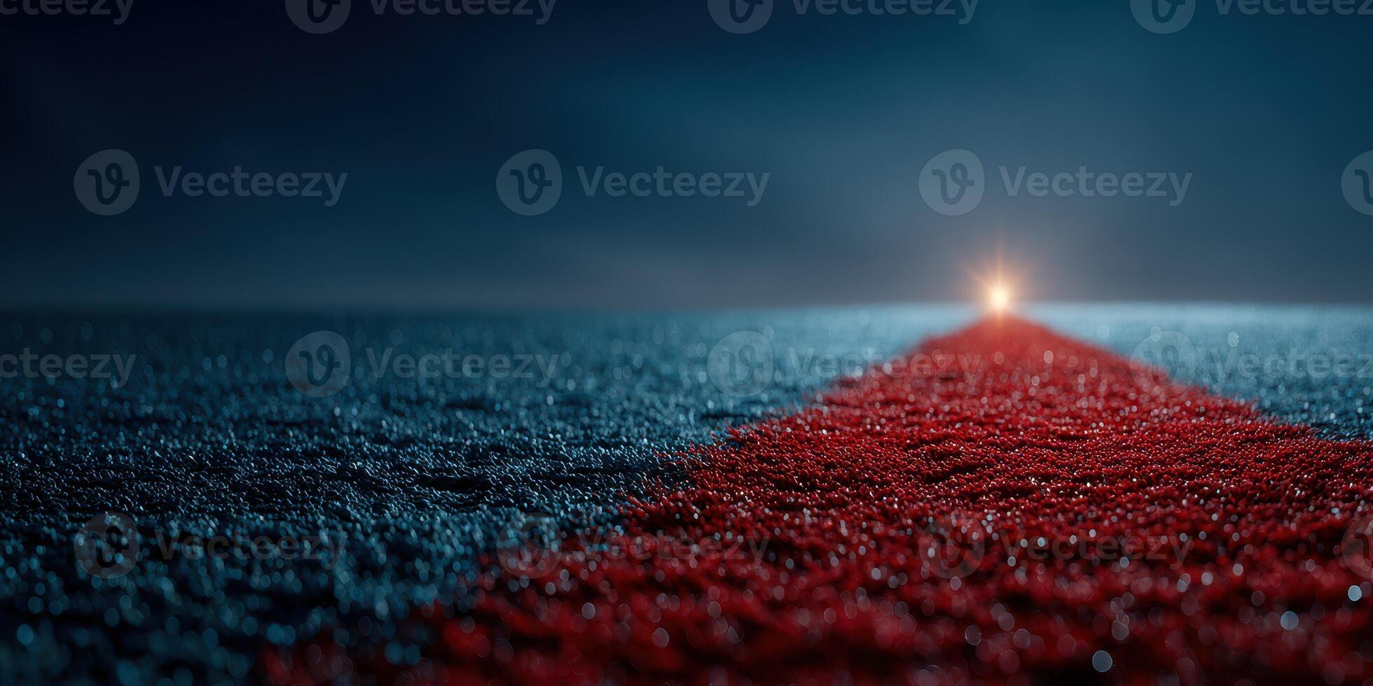 Bright light illuminates a red carpet stretching across a dark, wet road at night in a dramatic and atmospheric setting photo