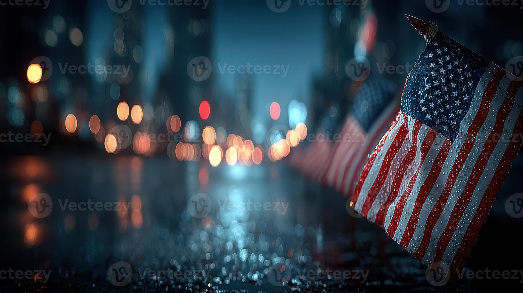American flags lined along a wet street at night in a city, illuminated by soft city lights photo