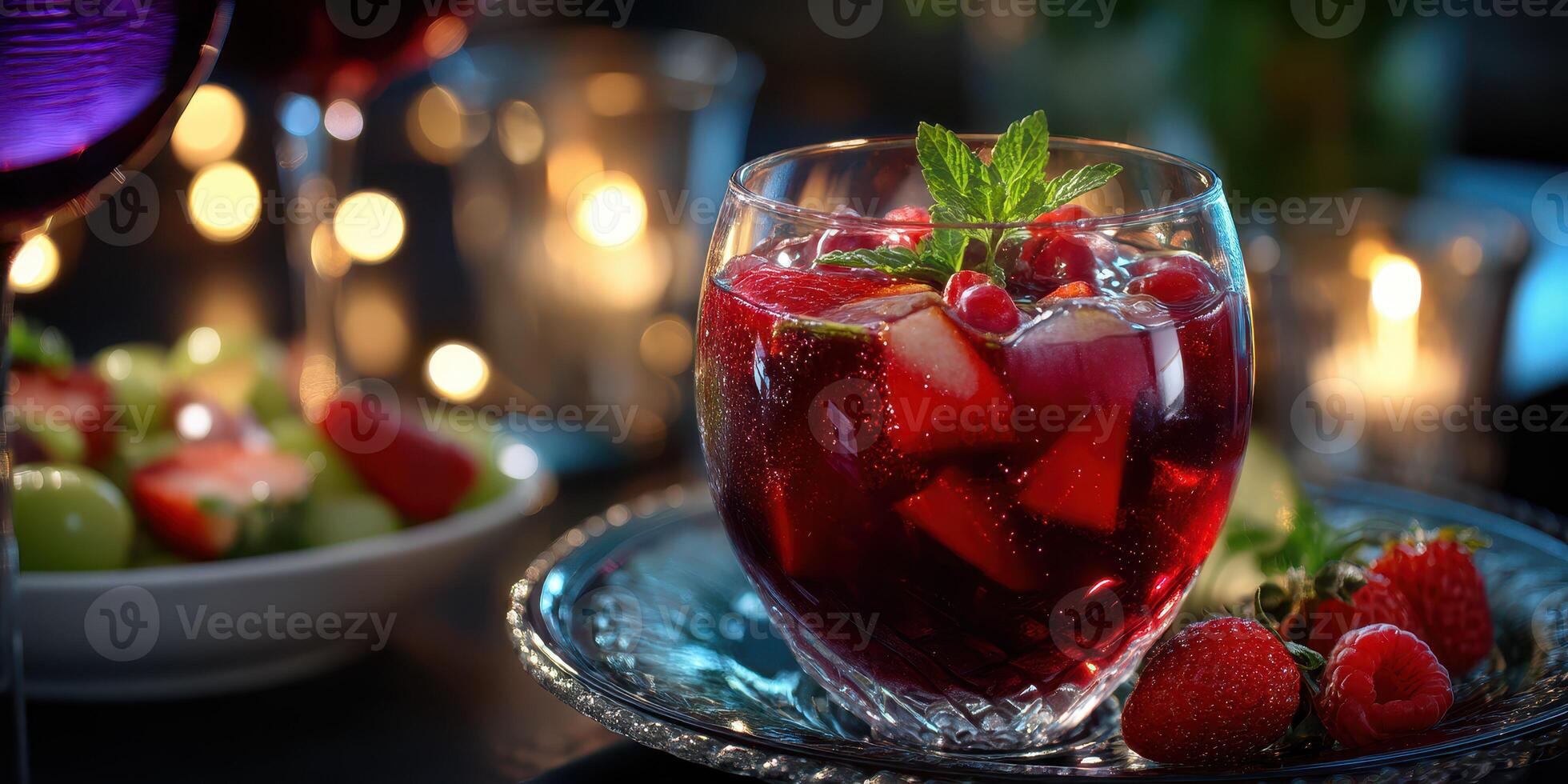 Refreshing red beverage garnished with mint and berries on a silver tray in an evening setting photo