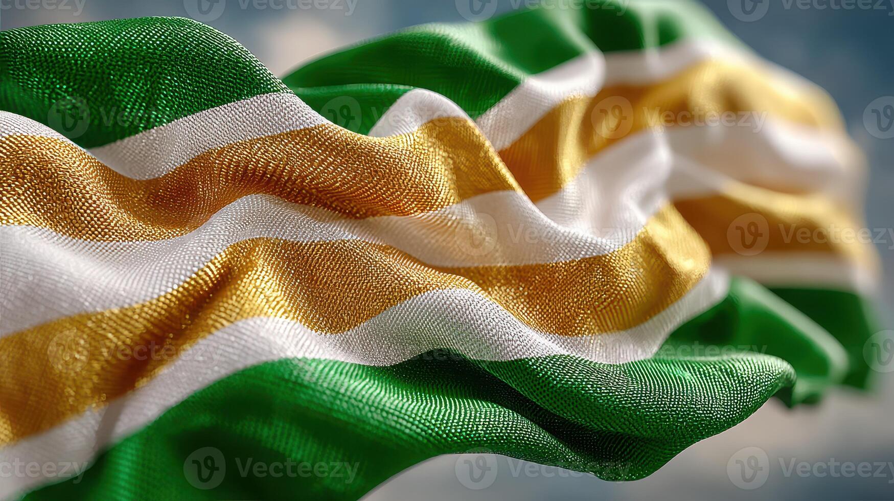 Waving flag of green, gold, and white fabric creating a dynamic display against a blue sky photo
