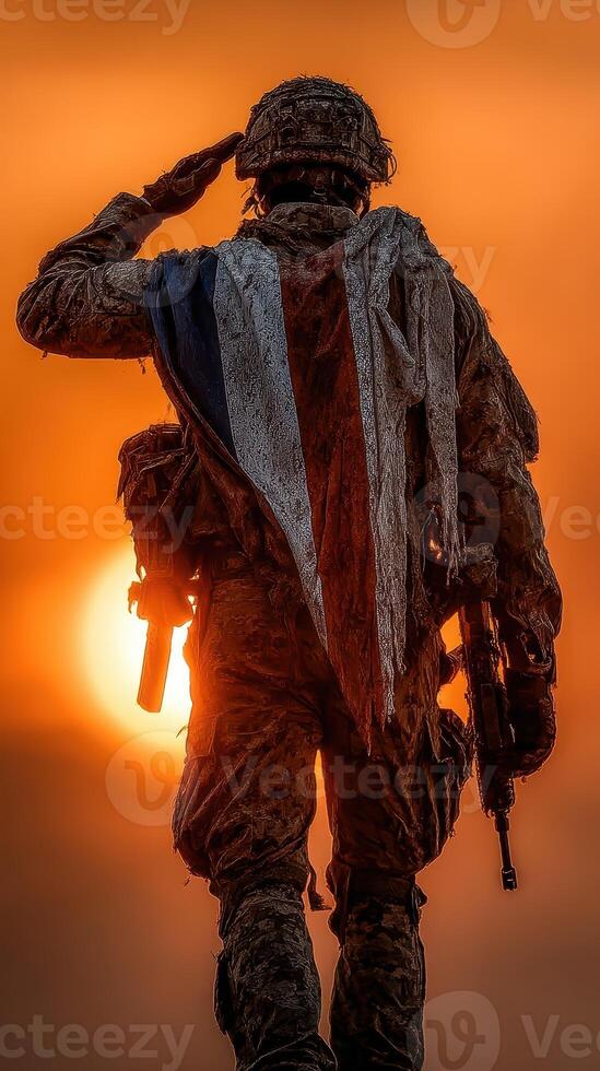 Soldier saluting against a vibrant sunset backdrop with tattered flag draped over shoulders at military training exercise photo