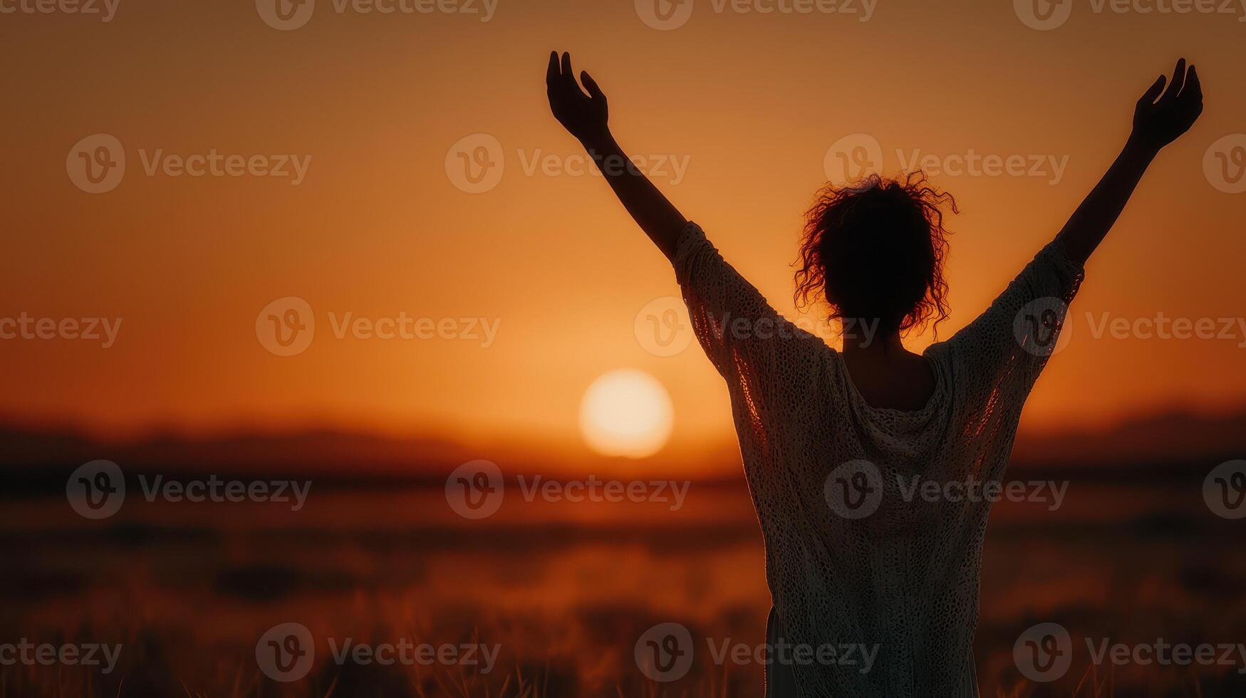 Woman enjoys sunset view while celebrating freedom in a serene outdoor setting photo