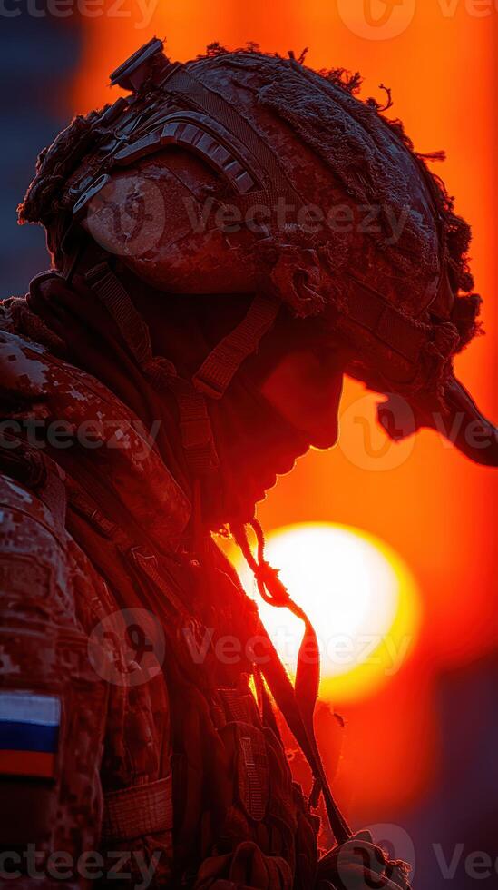 Soldier at sunset reflects on duty and service during a quiet moment in the field photo
