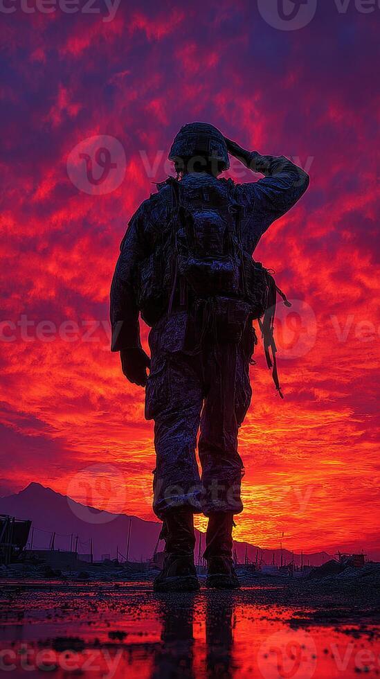 Soldier saluting against a vibrant sunset backdrop in a military setting photo