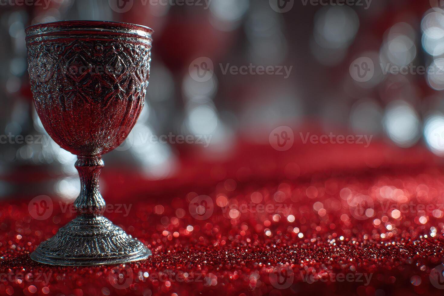 Elegant silver goblet on a sparkling red tablecloth at a festive gathering during evening celebrations photo