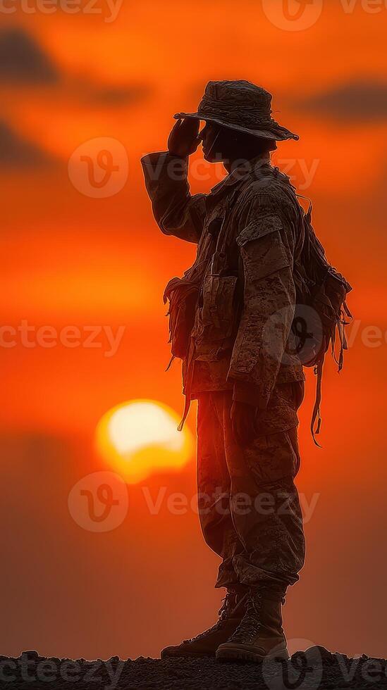 Soldier saluting against a vibrant sunset on a military training field photo