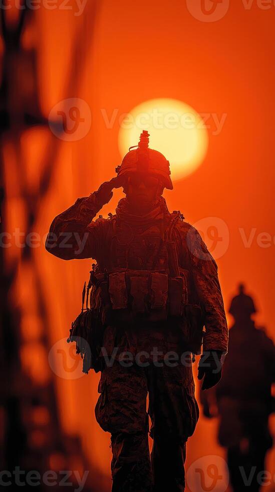 Soldier salutes during sunset, silhouetted against vibrant orange sky in a military operation photo