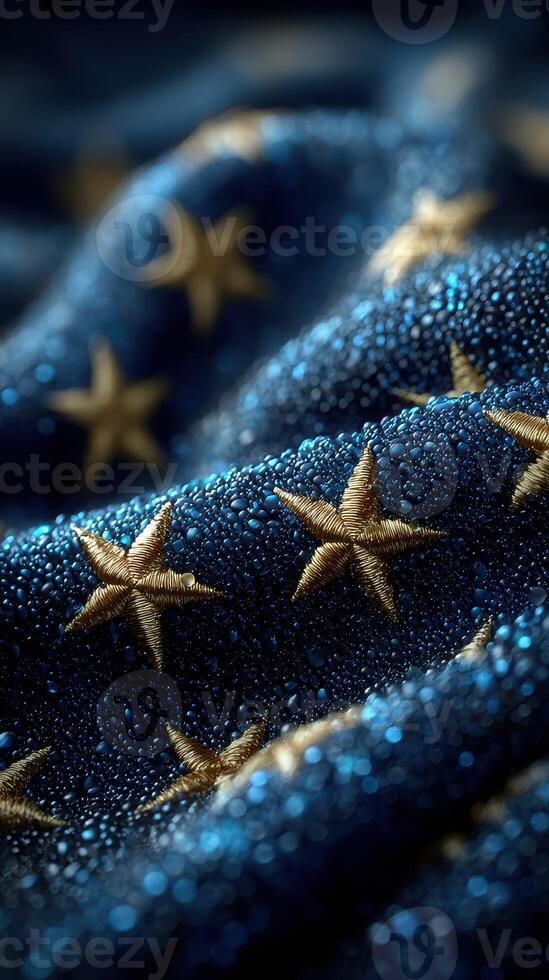 Golden stars shimmer on a blue fabric adorned with beads of moisture captured in the soft light of early morning photo
