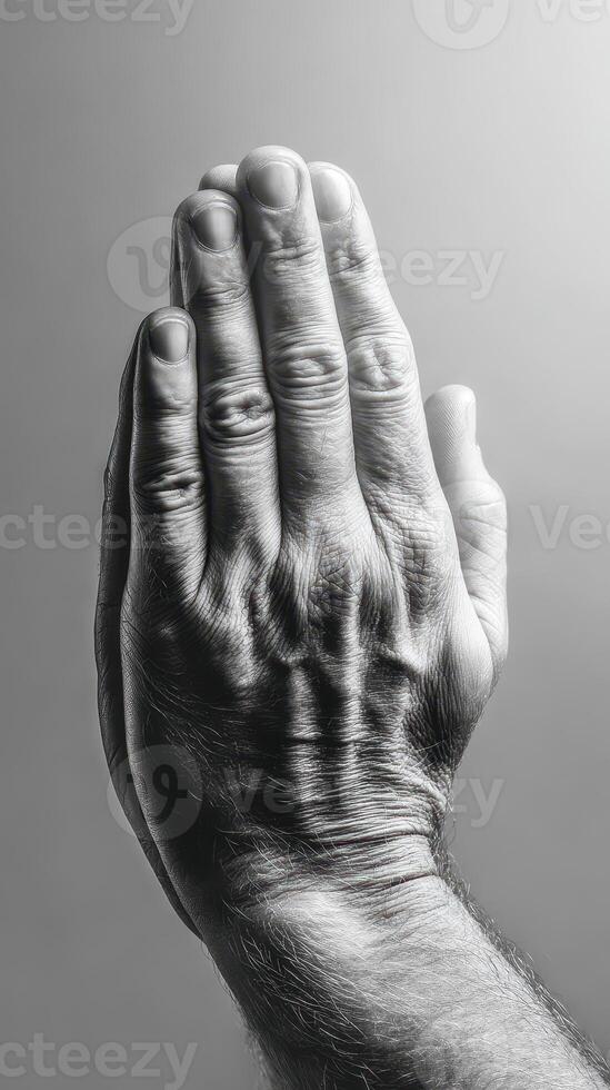 Hands together in a gesture of prayer or reflection captured in black and white during a quiet moment photo