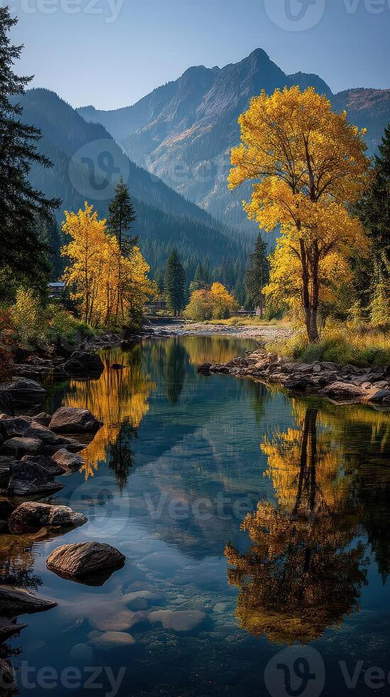 Majestic autumn scene with vibrant yellow trees reflecting in calm river surrounded by mountains during midday photo