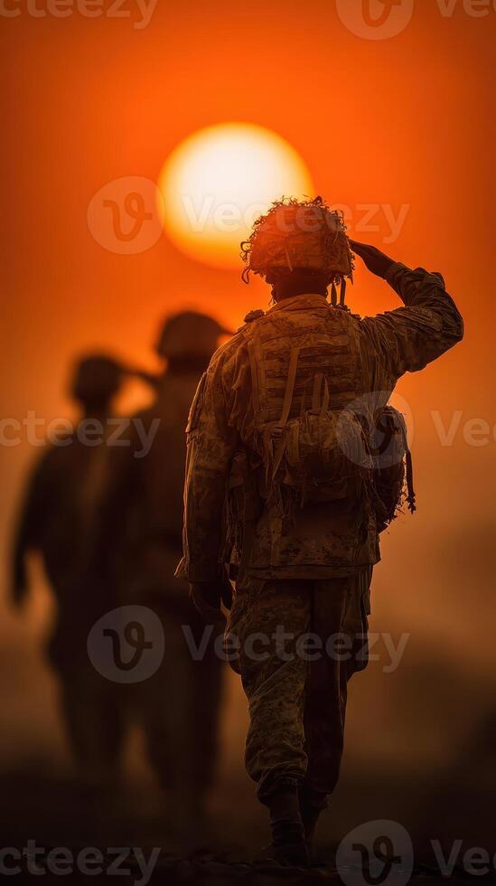 Soldiers salute at sunset with warm orange hues highlighting their silhouettes during a military training exercise photo