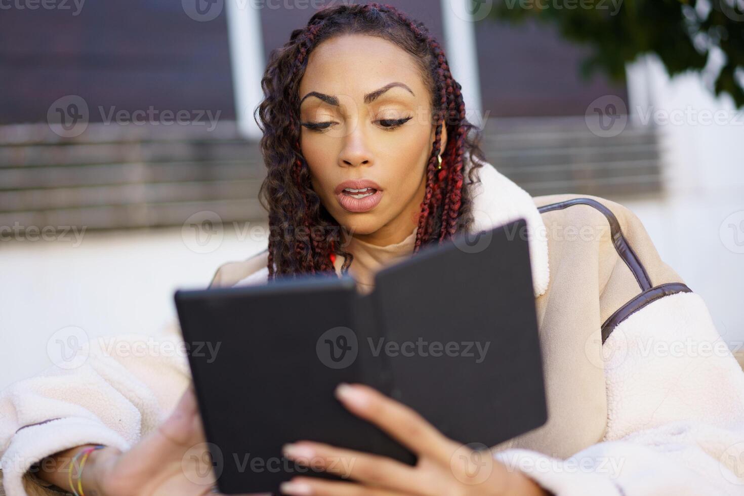 An Engaged Reader Is Enjoying Their Digital Book While Relaxing Outdoors in Natures Beauty photo