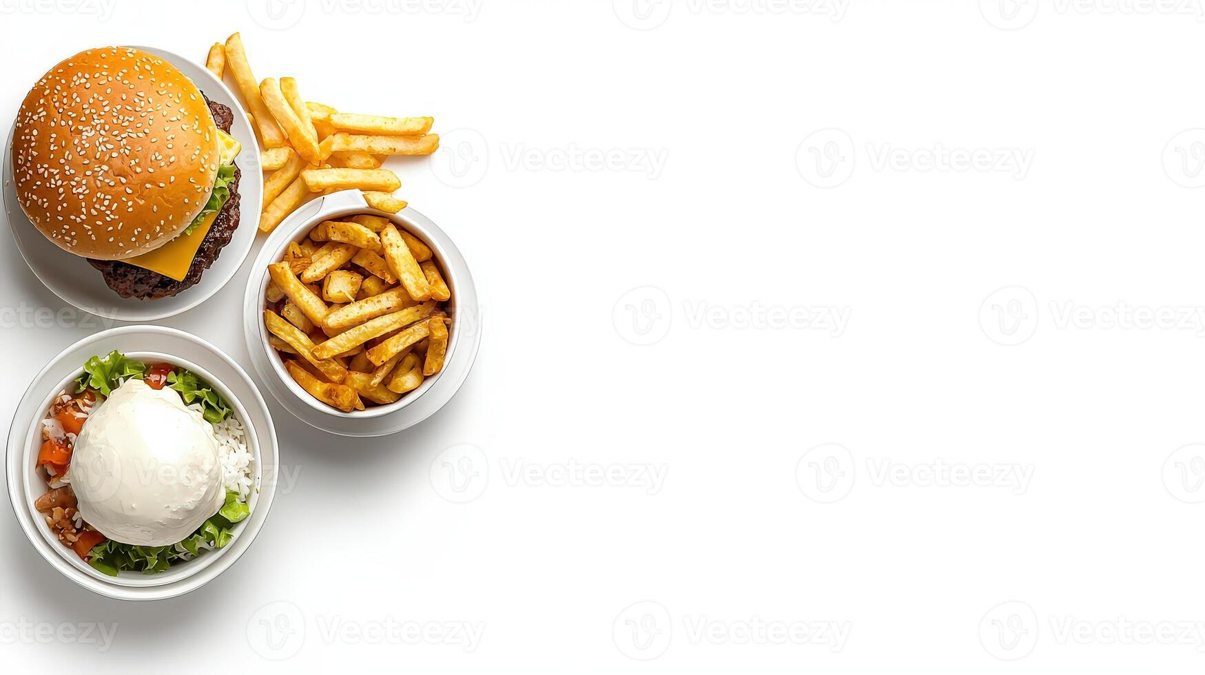 A hamburger, french fries and a salad are on a white surface photo