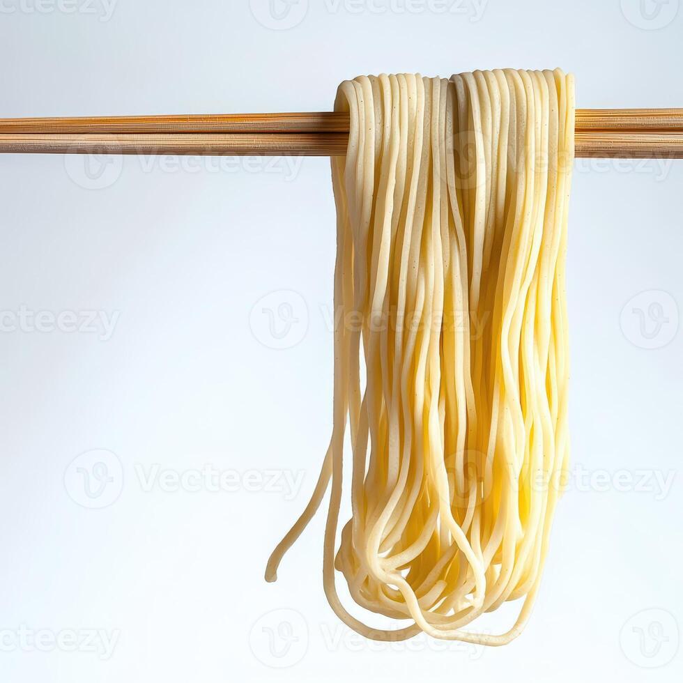 A pair of chopsticks holding a piece of noodles photo