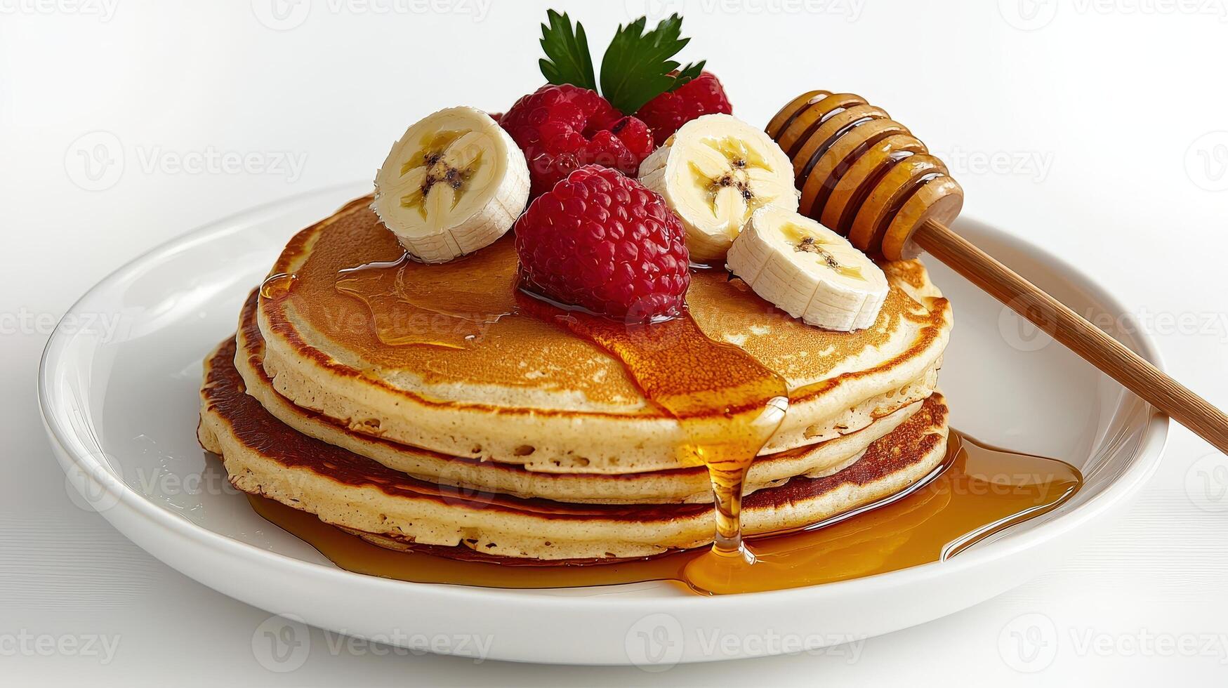 A stack of pancakes with bananas, raspberries and honey photo