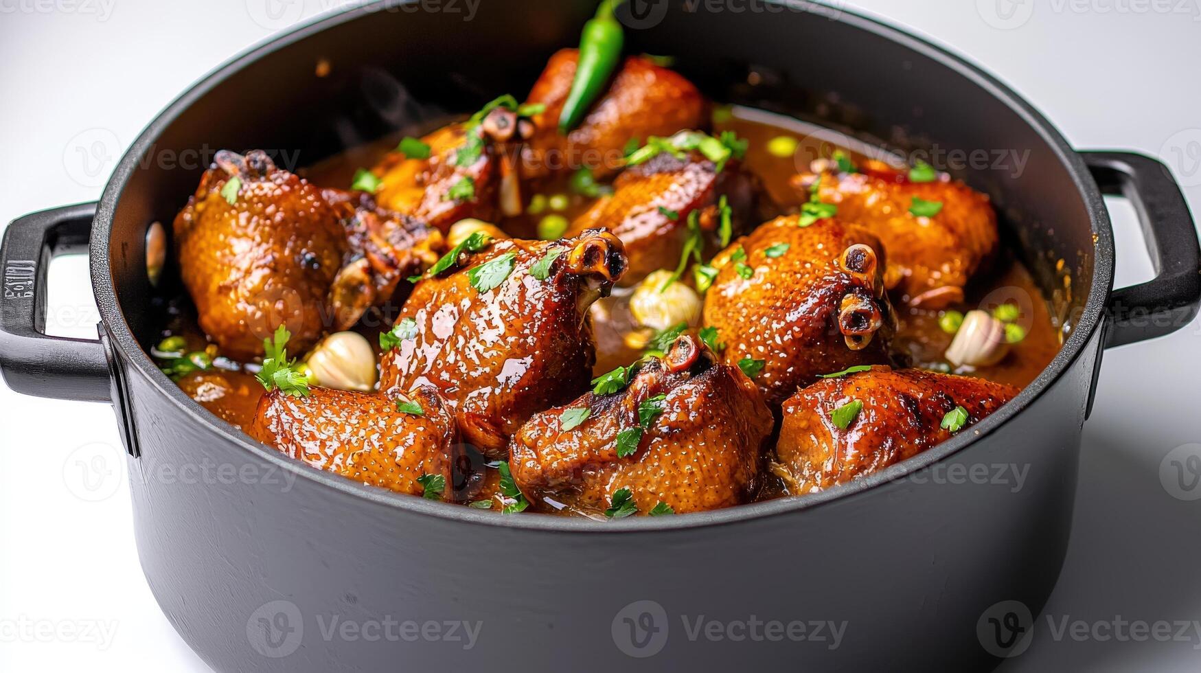 Chicken in sauce in a pot on a white surface photo
