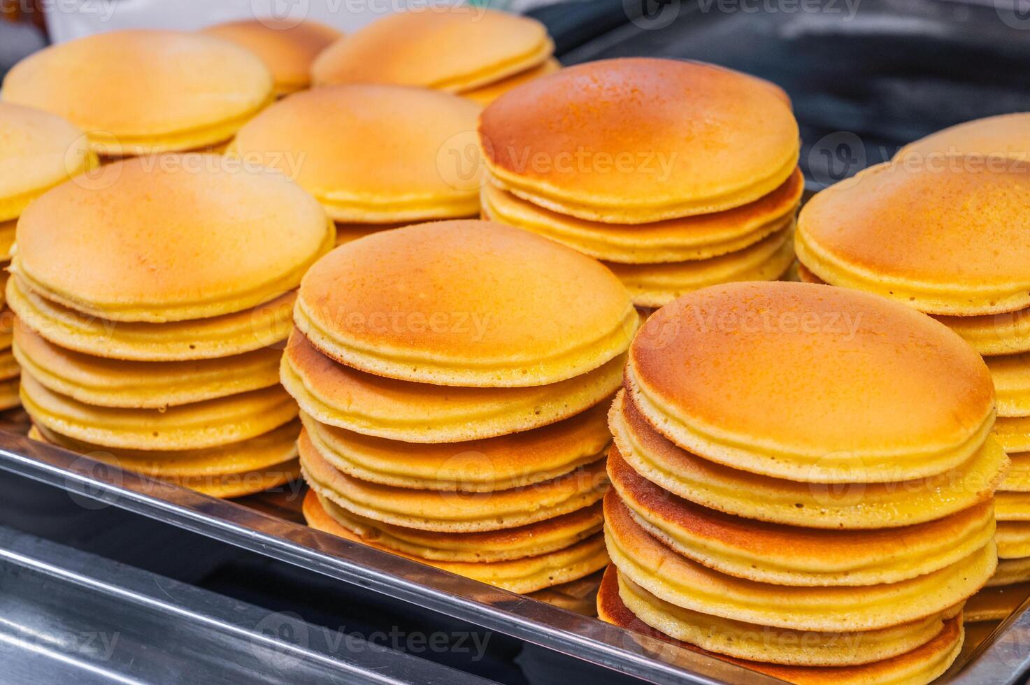 A stack of pancakes in close-up on a dark dish. photo