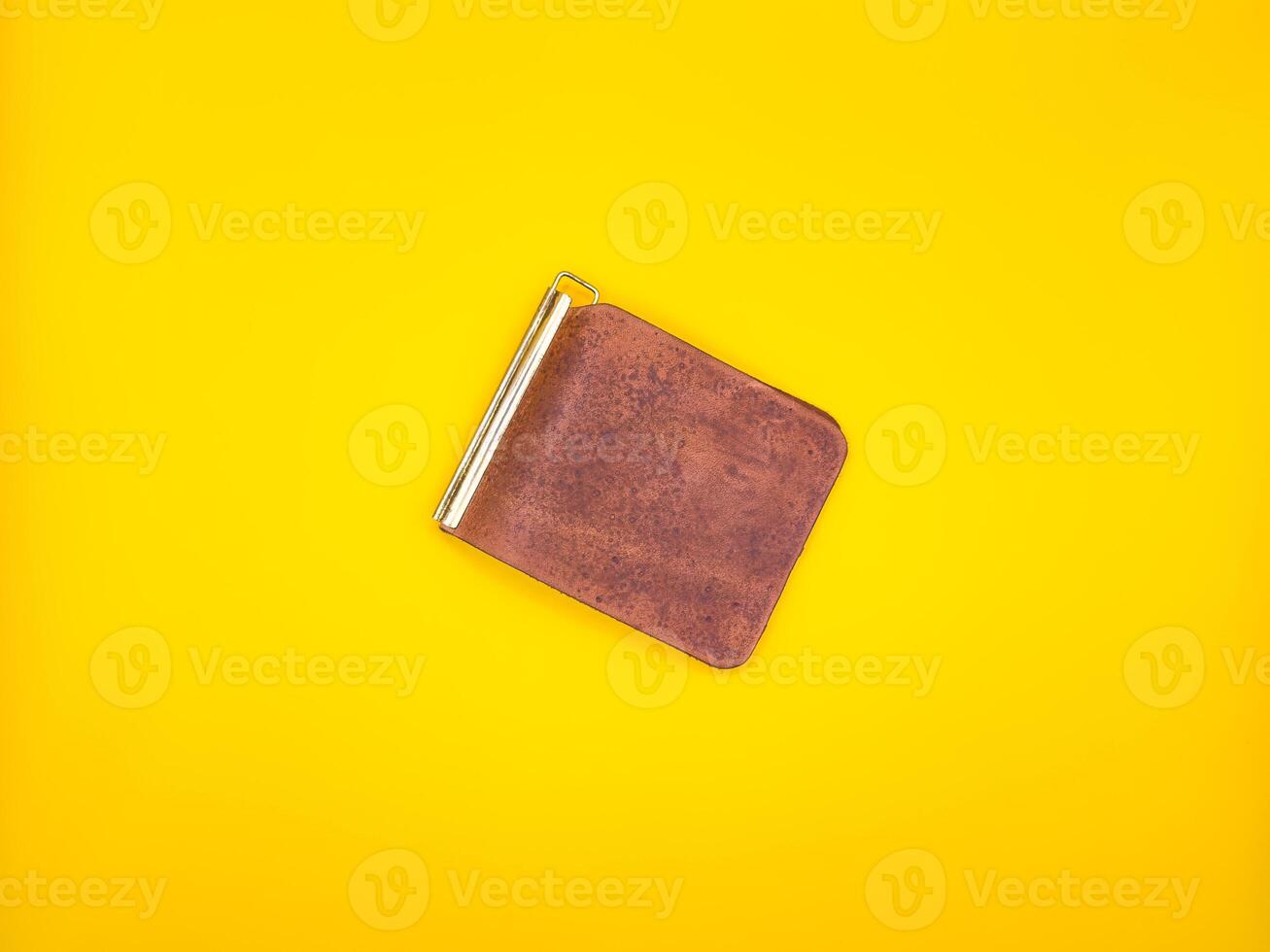 Fashionable brown men's leather wallet isolated on a yellow background. photo