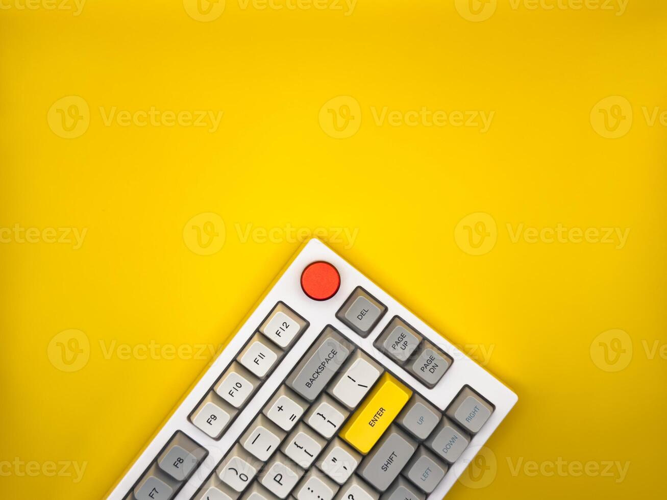Workspace desk with it keyboard, red and yellow buttons, with yellow background. Flat lay. Top view, copy space. photo