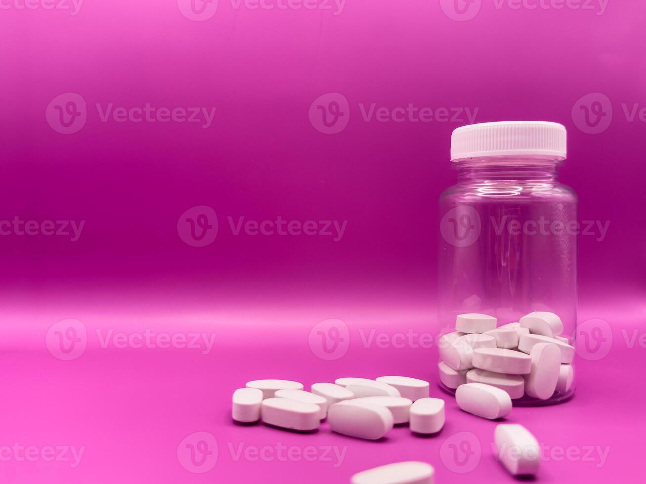 An bottle of white pills. Pills on a pink background. pills studio isolated over white. Covid 19 photo