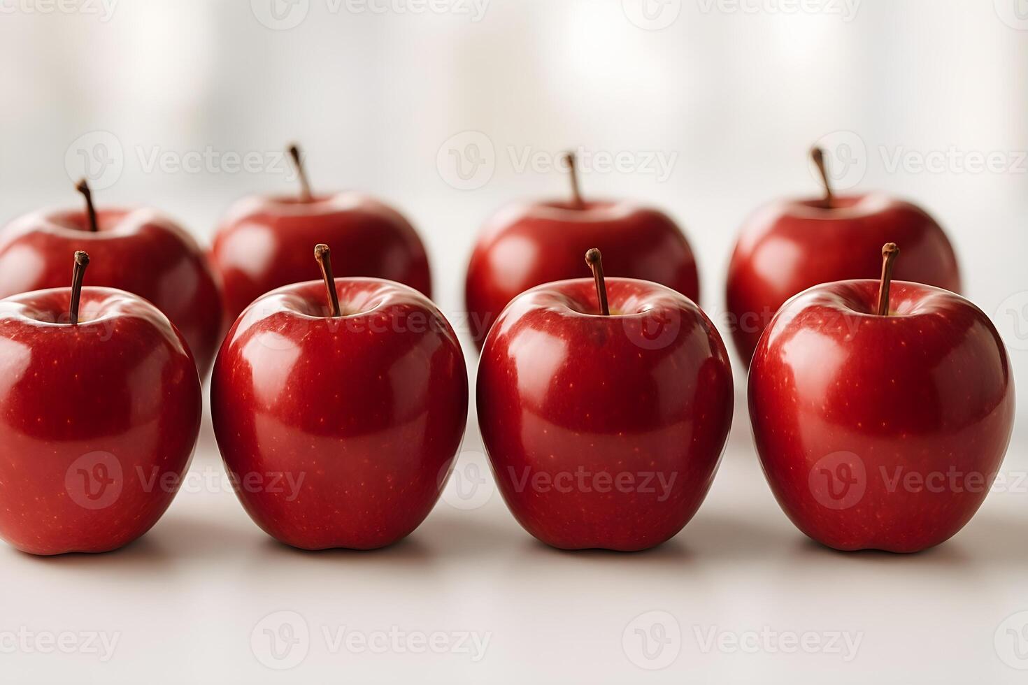 Glossy red apples placed symmetrically on a clean white surface with soft natural lighting. photo