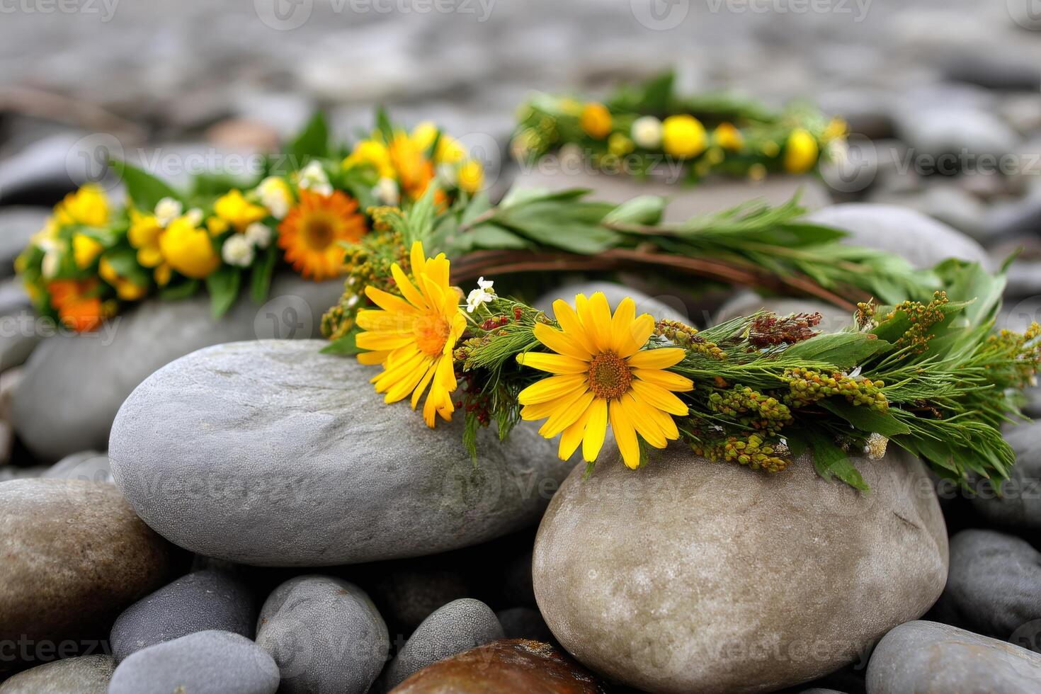 Flower crowns resting on smooth river stones photo