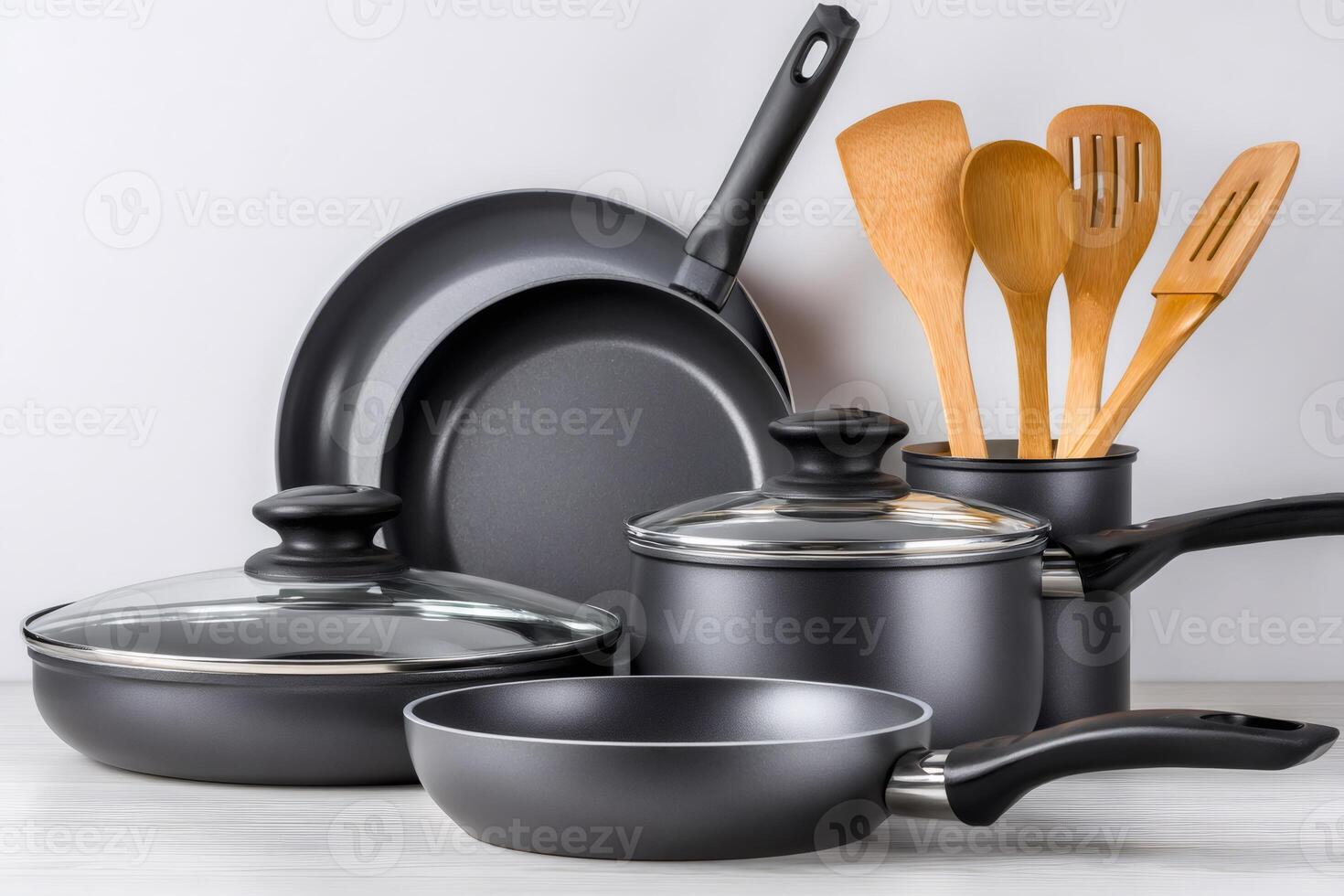 Set of cooking pots and pans with wooden utensils displayed on kitchen counter photo