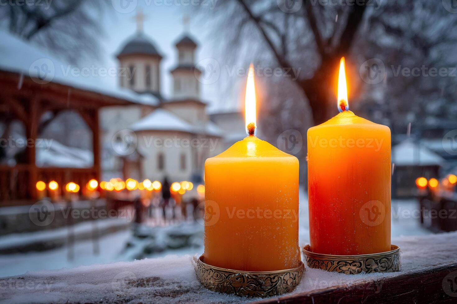 Burning candles illuminating snowy monastery during christmas eve photo