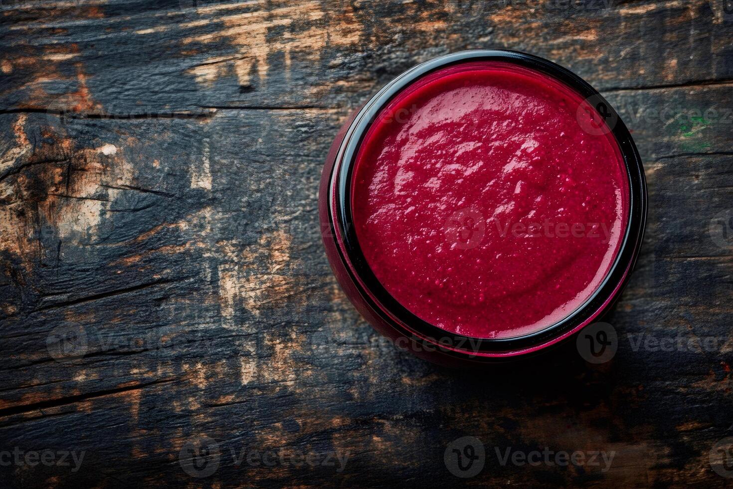 Beetroot hummus in glass jar on rustic wooden table photo