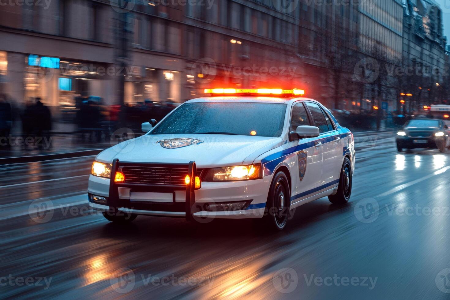 Police car driving on wet city street at night with flashing lights photo