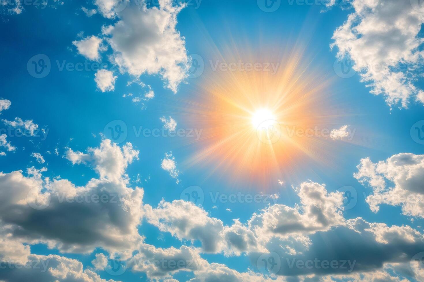 Bright midday sun shining through dramatic clouds in blue sky photo
