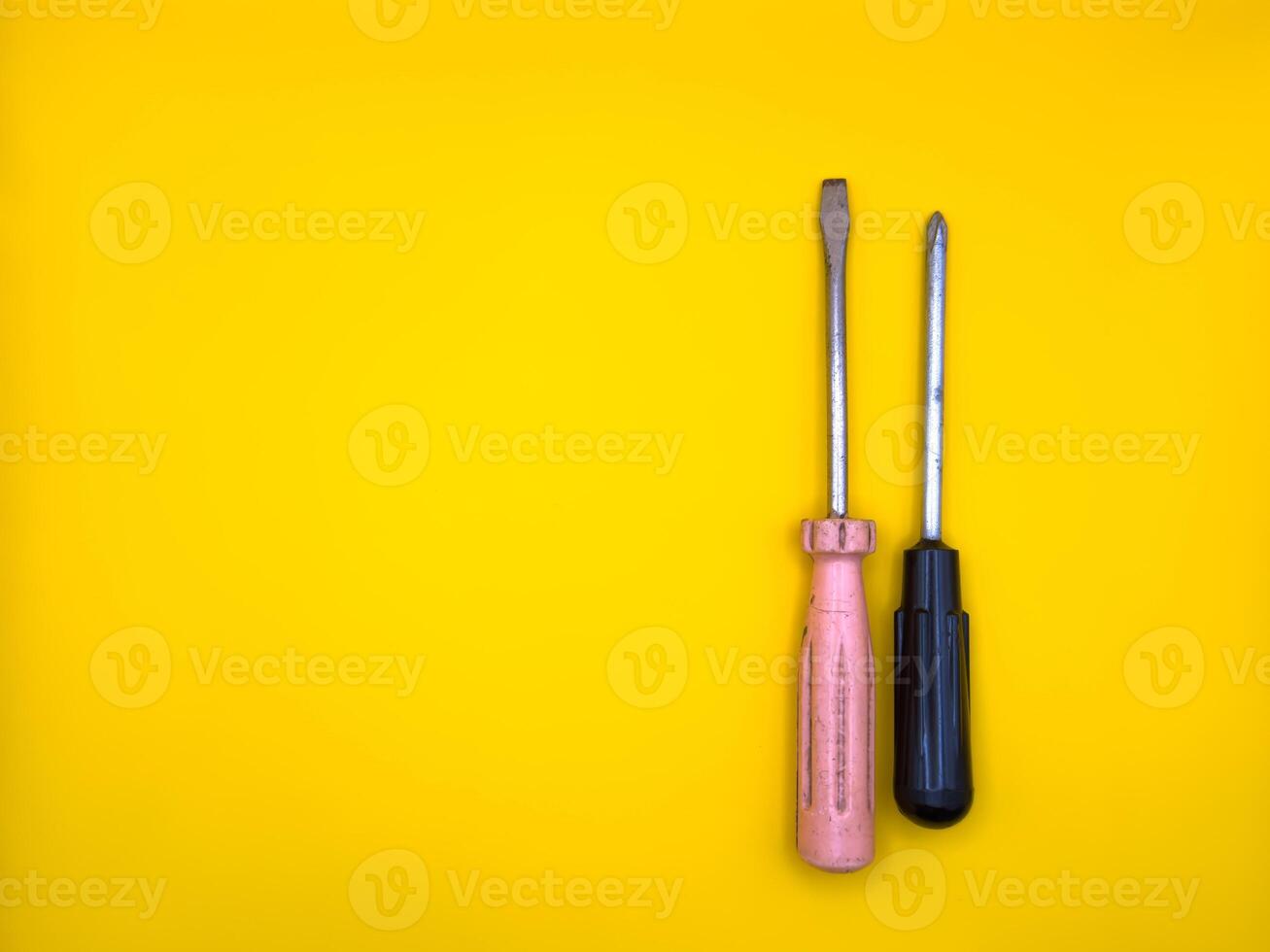 A flat screwdriver on isolated yellow background. Flat lay. Top view, copy space. photo