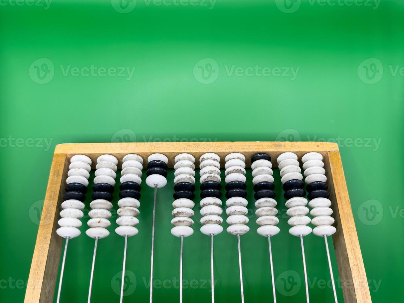 A classic wooden abacus with colorful beads arranged neatly on a vibrant green background. Ideal for early math learning, counting practice, and educational themes photo