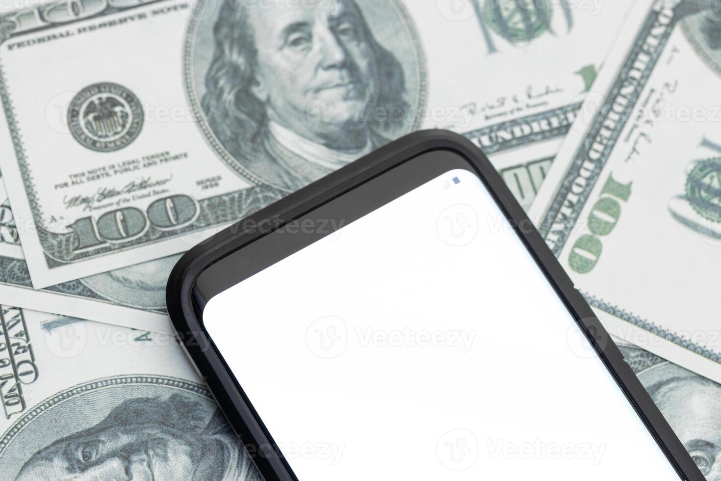 Smartphone with blank white screen on US dollar bills background. Mockup template photo