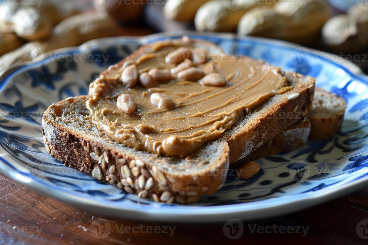 Two slices of whole wheat bread with peanut butter and peanuts on a decorative plate photo